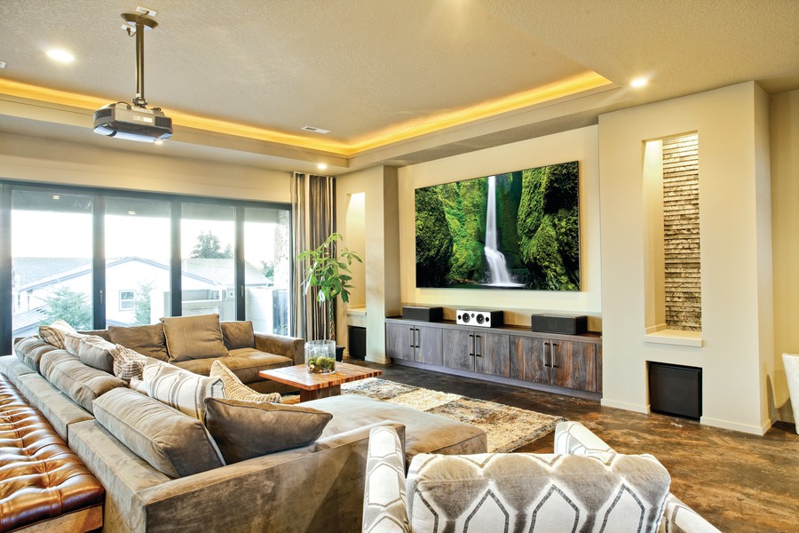 Image is of a living room with a flat screen TV mounted on the wall.