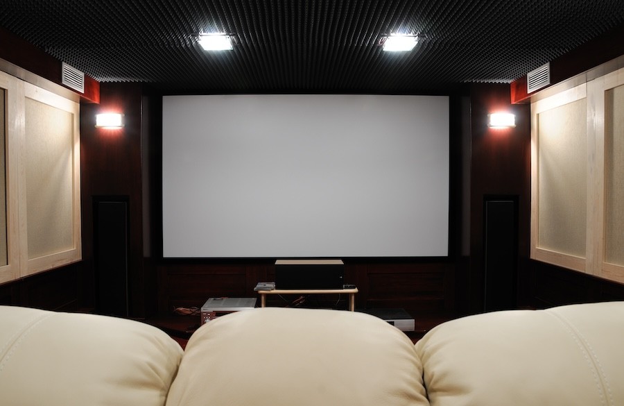 A home theater with a big screen and a cushy couch.