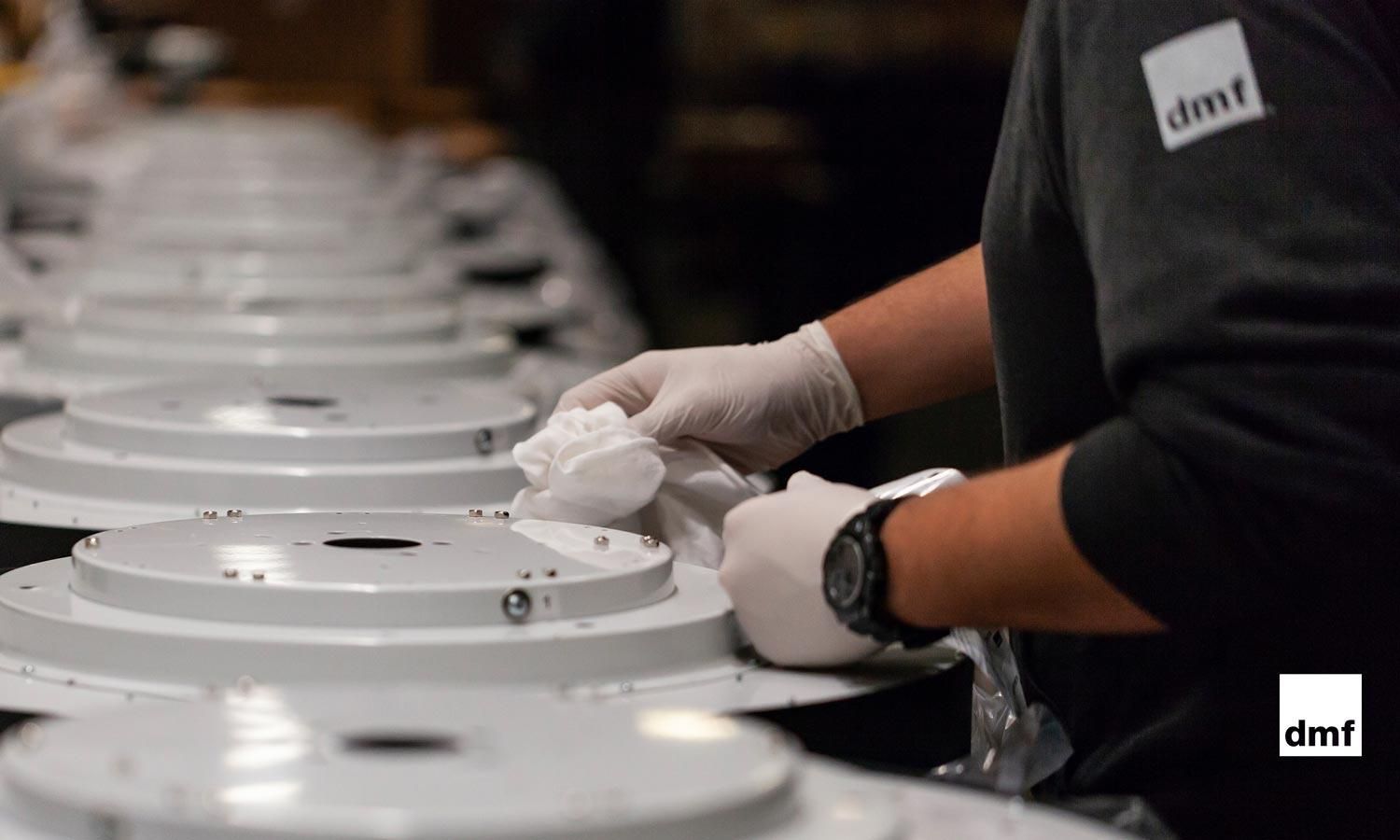 Close-up of a technician meticulously assembling a DMF Lighting fixture, showcasing the brand’s commitment to craftsmanship and quality.